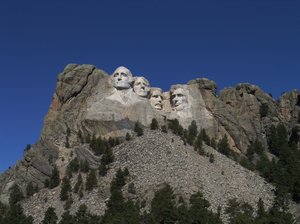 Faces of America - Mt Rushmore: Four Presidents of the United States forever carved into granite on the side of the mountain.  Mount Rushmore National Monument, South Dakota.