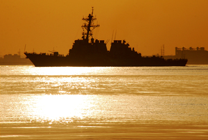 Warship at Sunset: A warship heading out to sea at sunset